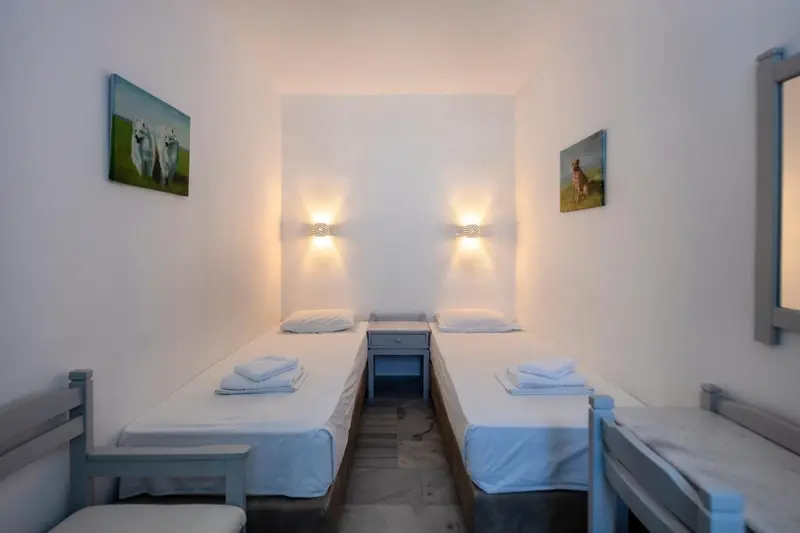 Une chambre lumineuse avec deux lits simples et des tableaux décoratifs.