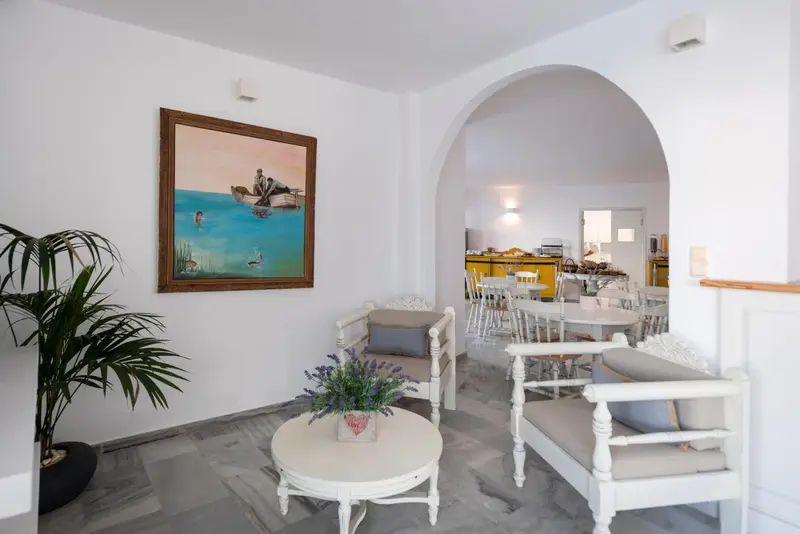 Espace de détente avec des fauteuils et une table basse devant un tableau.