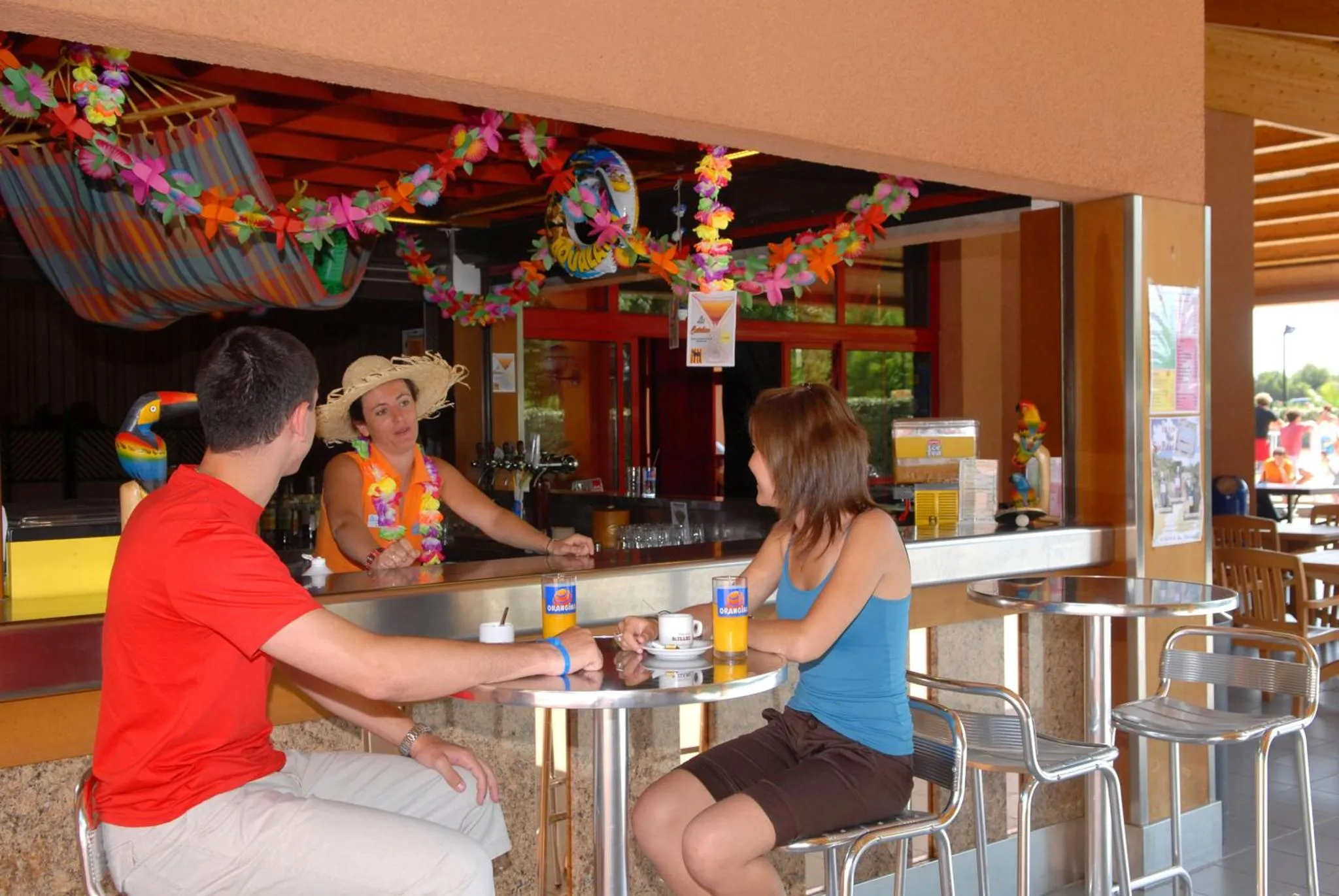 Un comptoir de bar coloré avec des clients assis et des boissons.