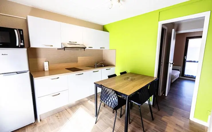 Une cuisine moderne s'ouvre sur une salle à manger lumineuse.