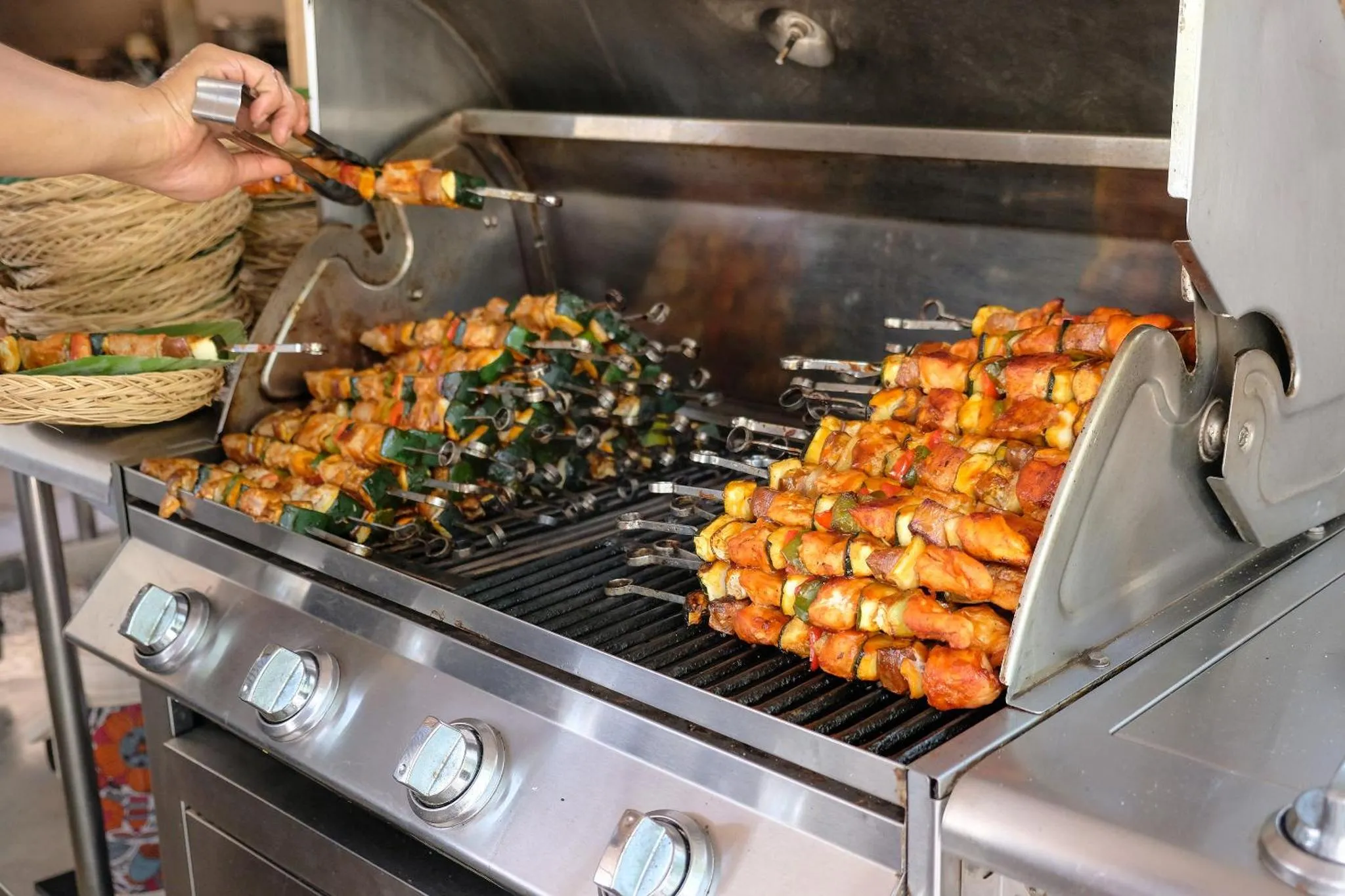 Brochettes de viande et de légumes grillées sur un barbecue en acier inoxydable.