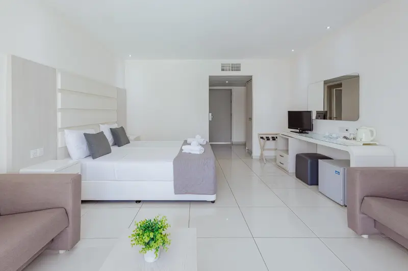 Une chambre lumineuse avec un grand lit et un espace détente.