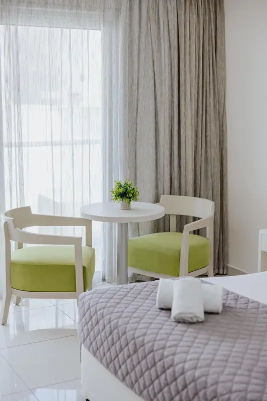 Un coin salon avec deux fauteuils et une petite table basse près d'une fenêtre.
