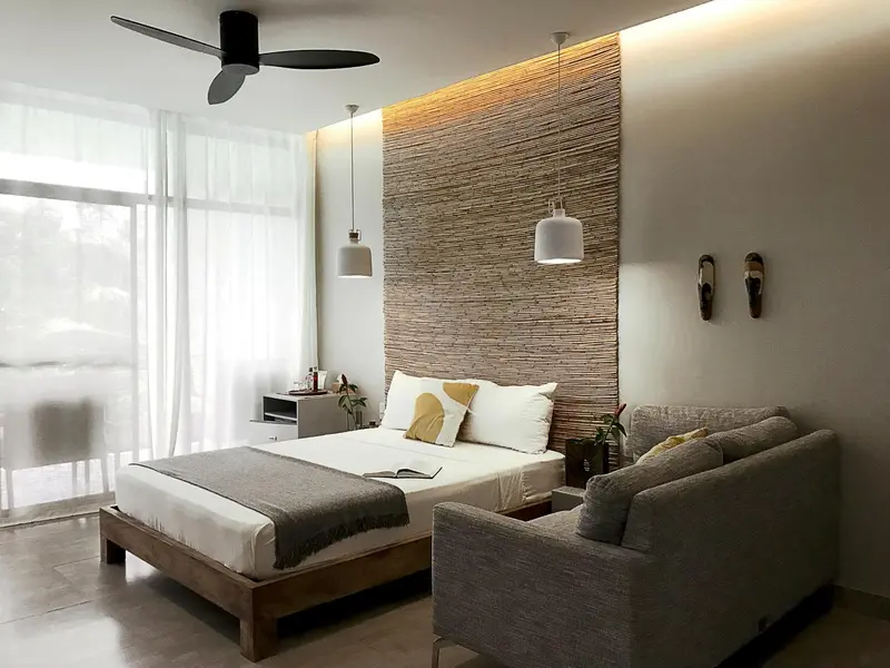Une chambre lumineuse avec un lit et un coin salon.