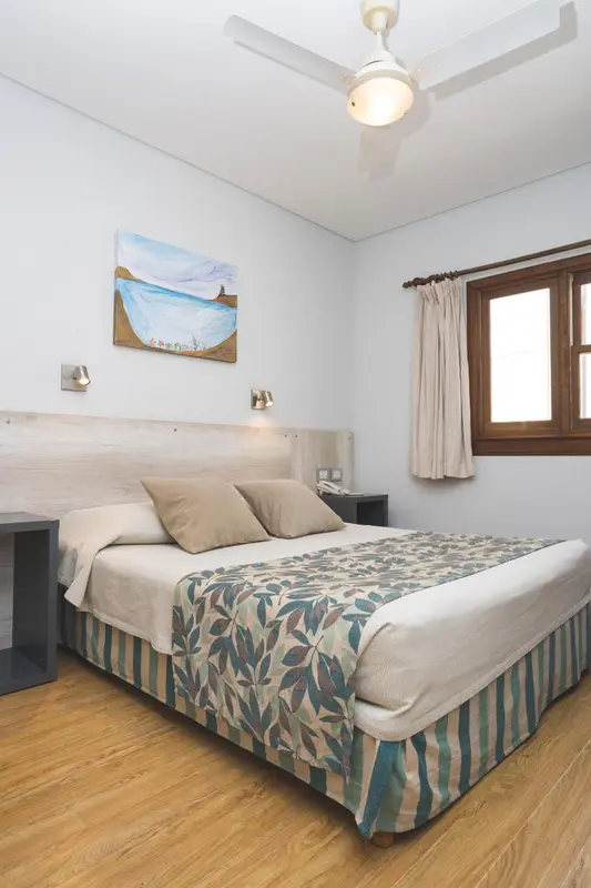 Une chambre lumineuse avec un lit double et une décoration sobre.