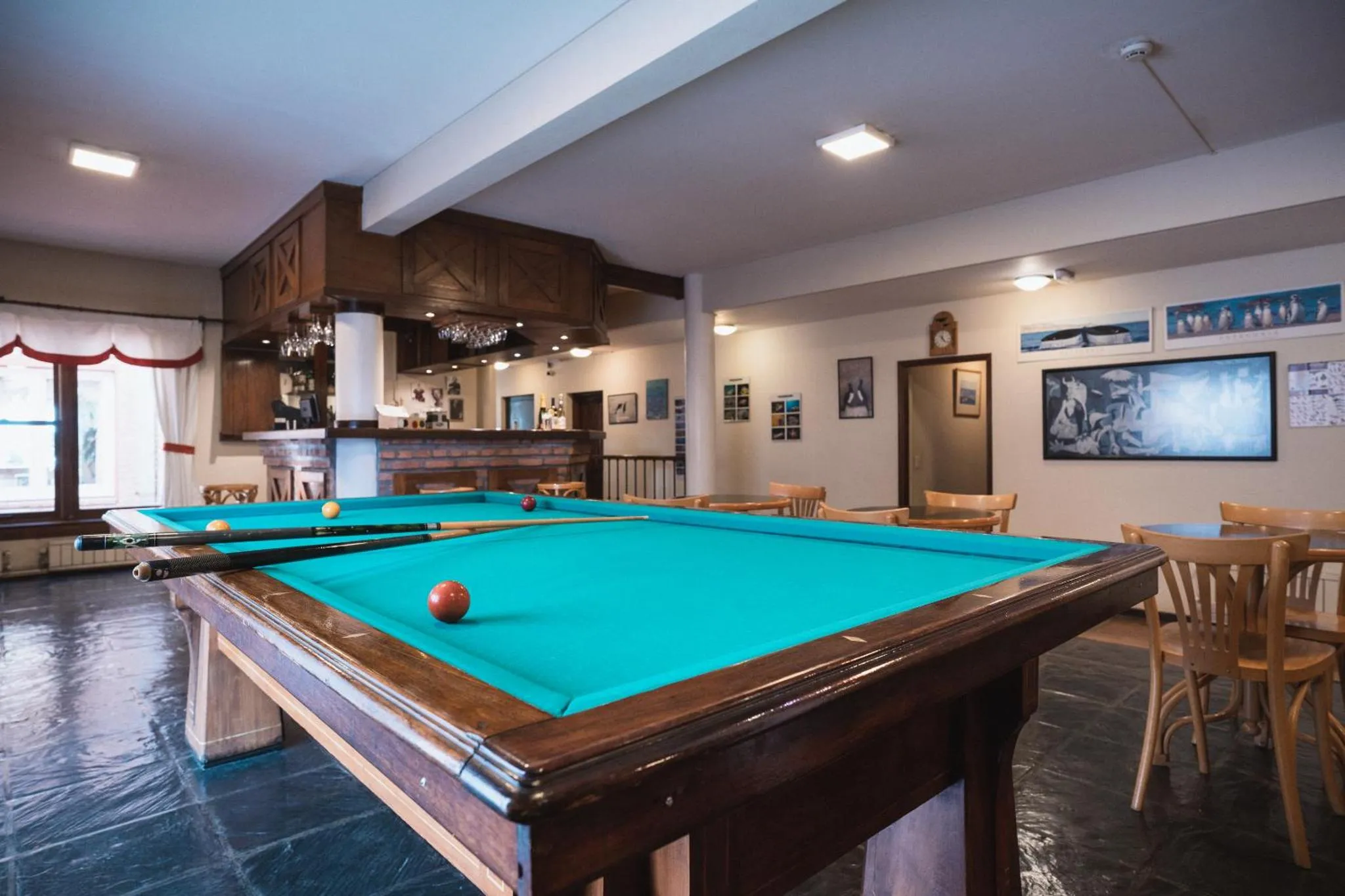 Une salle de détente avec un billard et un bar en fond.