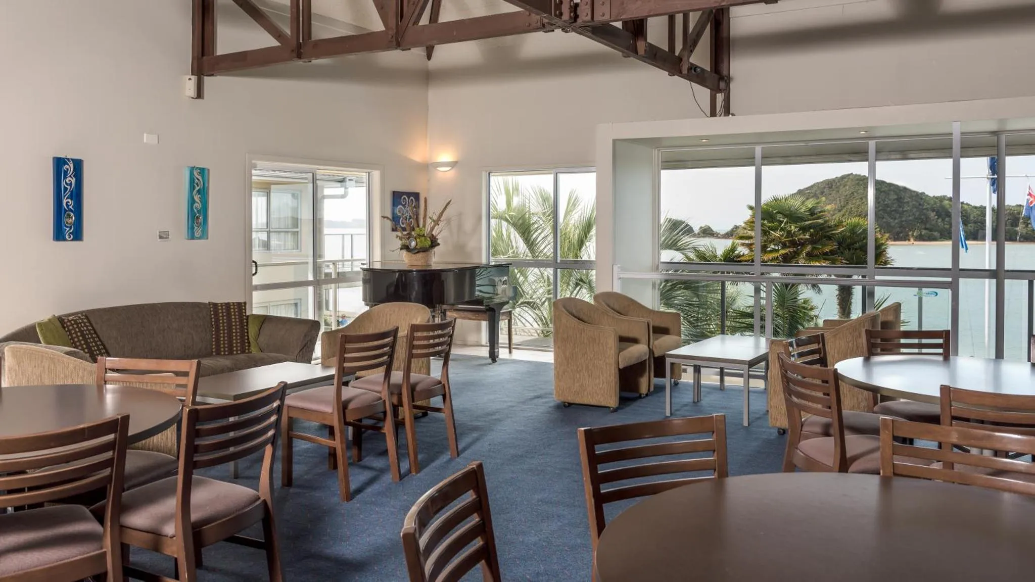 Espace de détente intérieur avec canapés, tables et vue sur la mer.