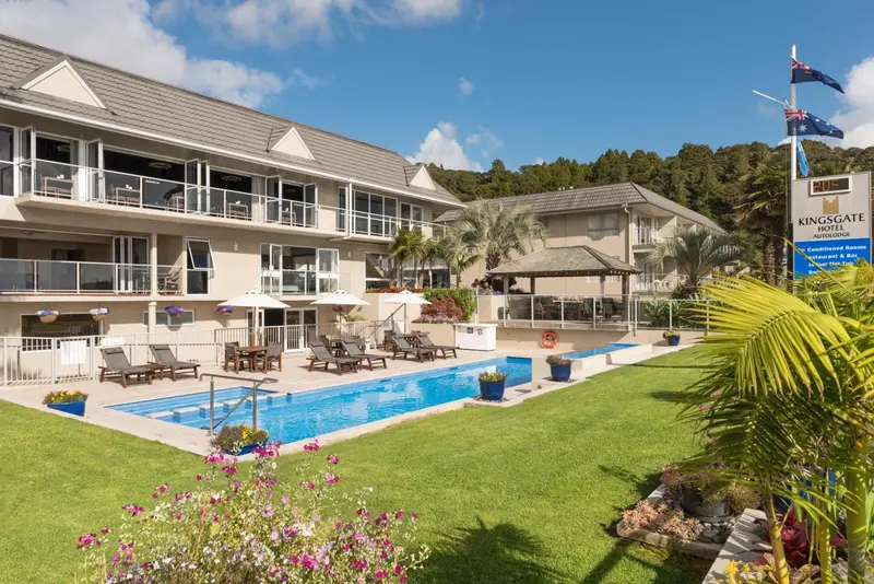 Bâtiment à plusieurs étages avec piscine et pelouse verdoyante.