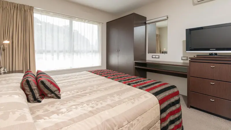 Une chambre lumineuse avec un grand lit et un bureau.