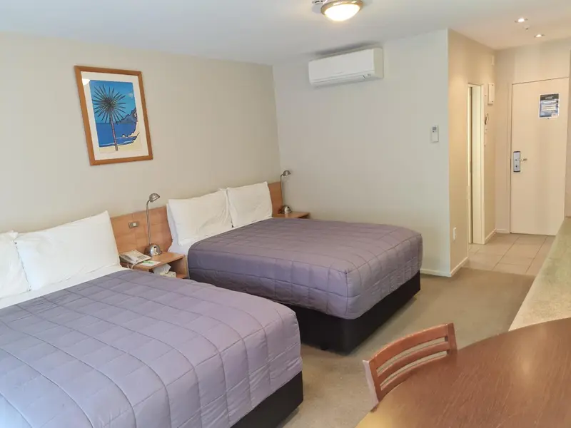 Une chambre avec deux lits simples et une table.