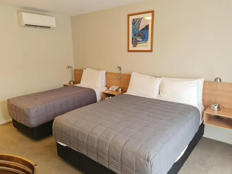 Une chambre avec deux lits simples et une décoration murale.