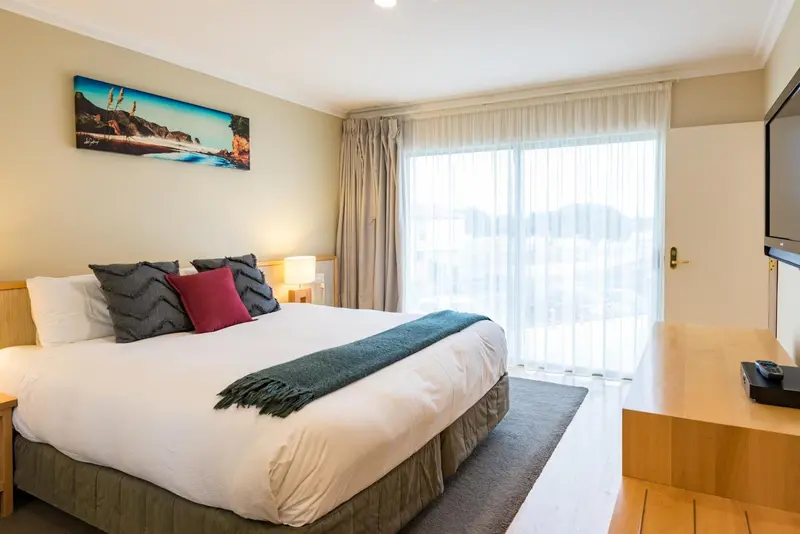 Une chambre lumineuse avec un grand lit et une vue sur le paysage.