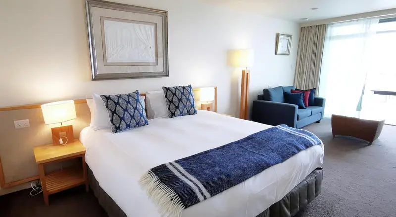Une chambre lumineuse avec un grand lit et un canapé confortable.