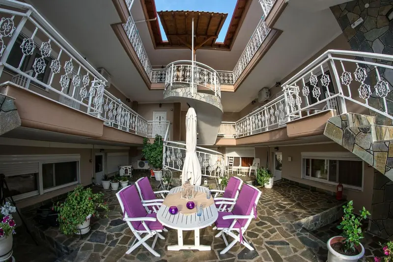 Cour intérieure d'un bâtiment avec des balcons et des tables de jardin.