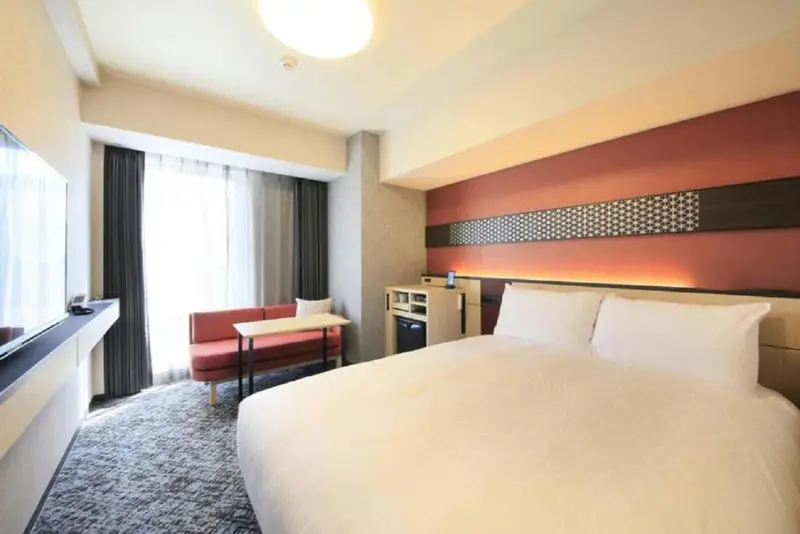 Chambre moderne avec un lit double et un coin salon.
