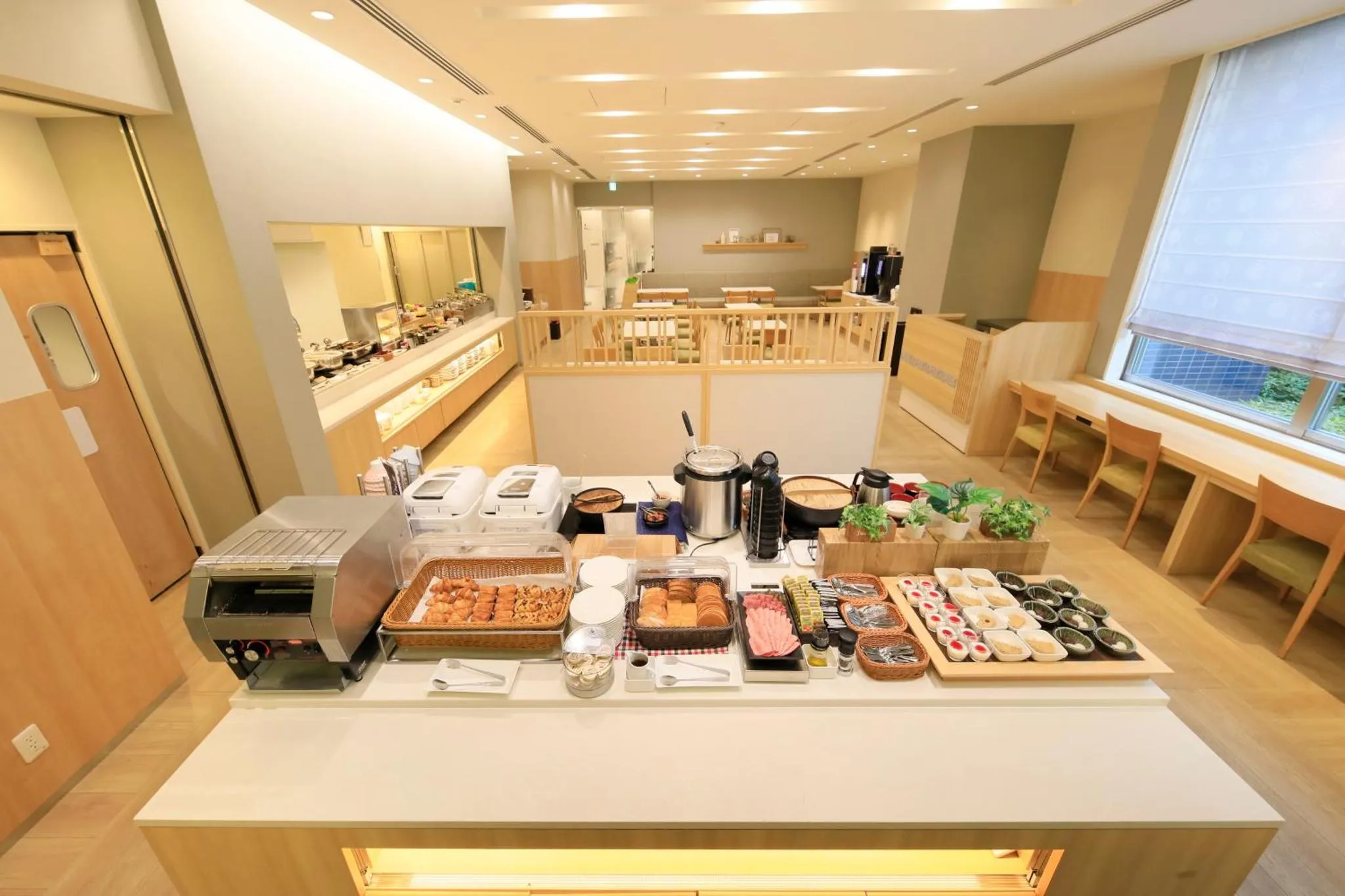 Un buffet propose une variété de plats et de boissons dans une salle lumineuse.