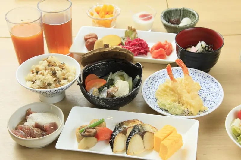 Une table est dressée avec une variété de plats japonais pour le petit-déjeuner.