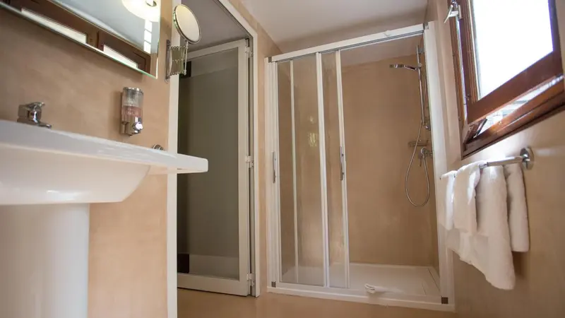 Une salle de bain avec douche et lavabo.