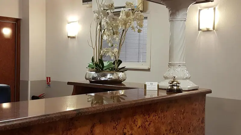 Un comptoir d'accueil décoré de fleurs et d'une cloche.