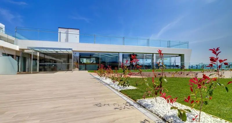 Terrasse moderne avec vue sur la mer et végétation soignée.