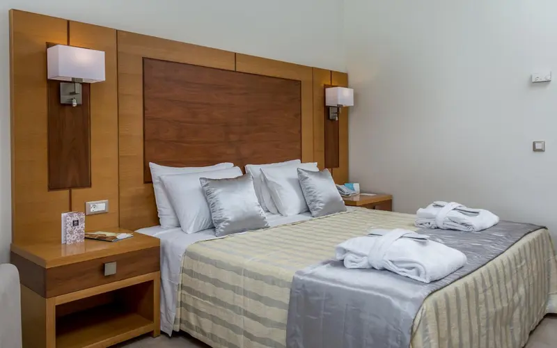 Un lit double avec des oreillers et une couverture dans une chambre.