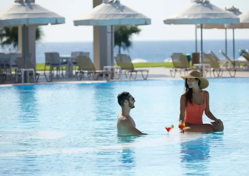 Un couple se détend au bord d'une piscine ensoleillée.