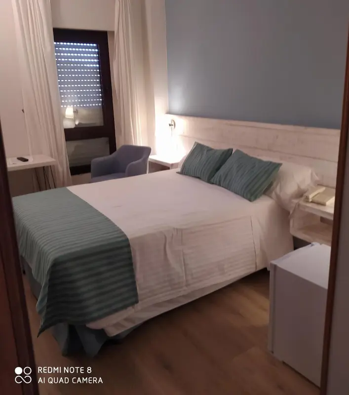 Une chambre avec un lit double et une chaise.