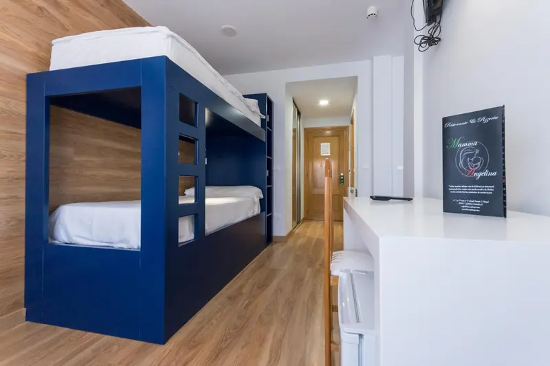 Une chambre avec des lits superposés et un bureau.