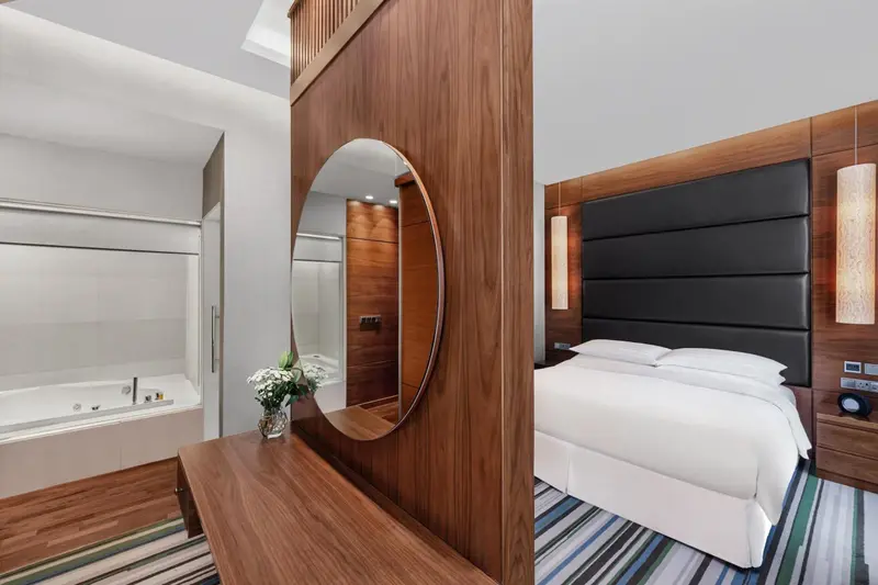 Une chambre moderne avec un lit blanc et une baignoire à remous.