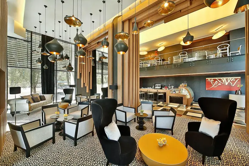 Un espace de détente intérieur avec des fauteuils et des luminaires suspendus.