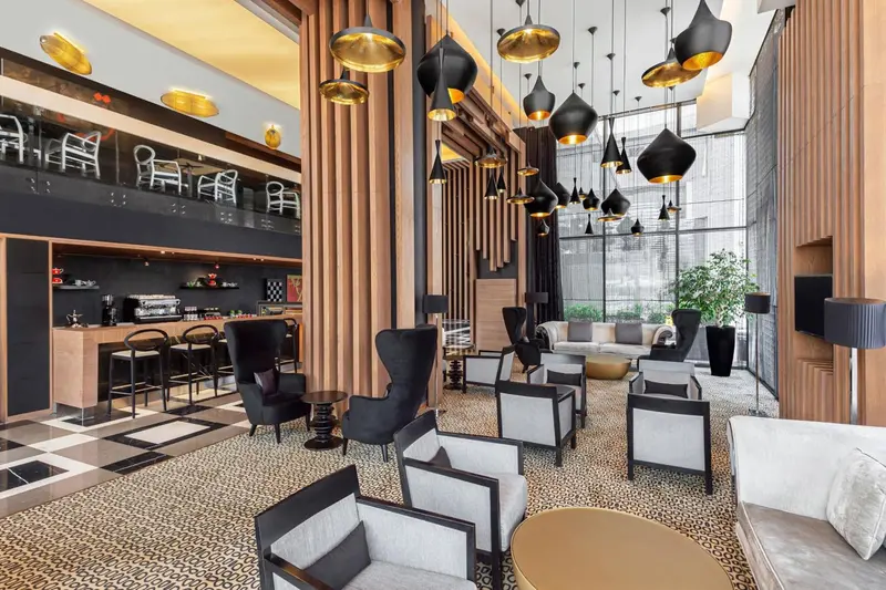 Un espace salon moderne avec un bar et des luminaires suspendus.