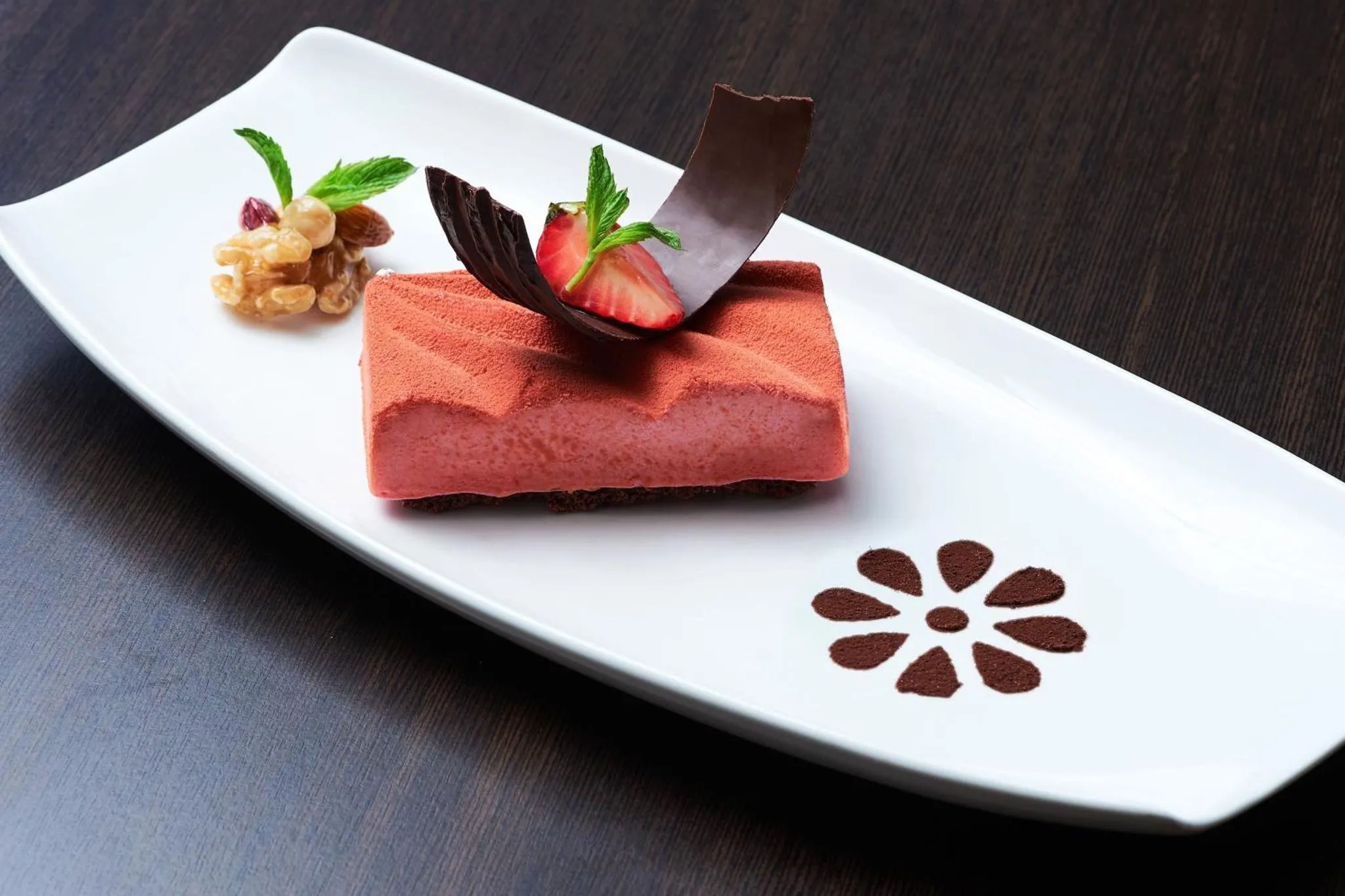 Une part de dessert rectangulaire est présentée sur une assiette blanche.