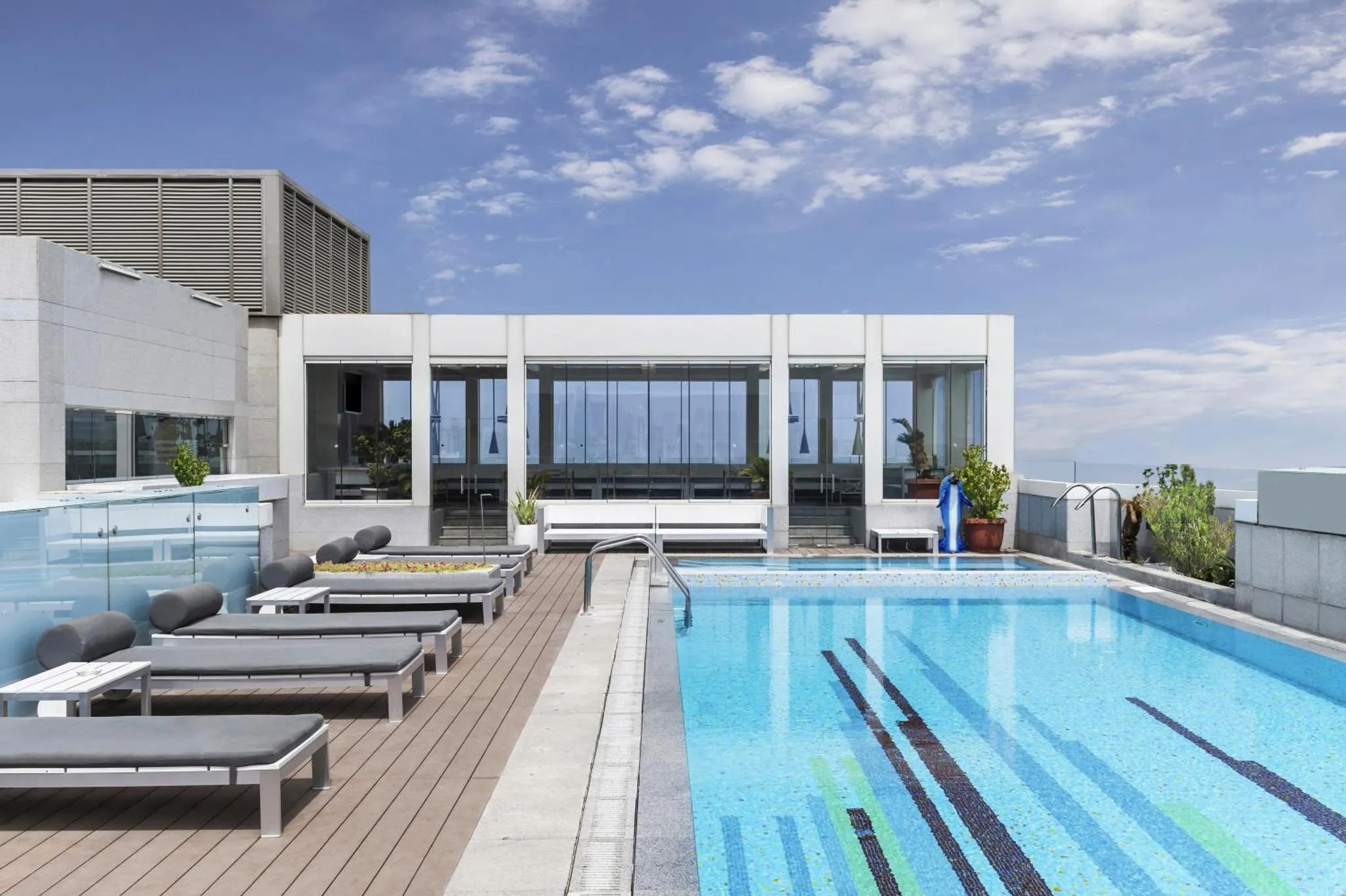Terrasse avec piscine et chaises longues au bord de l'eau.