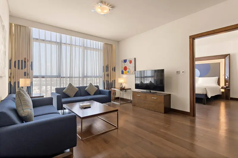 Un salon lumineux s'ouvre sur une chambre à coucher.