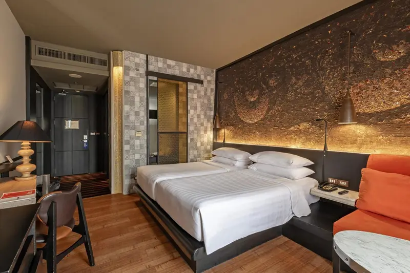 Une chambre avec un grand lit et un coin salon.