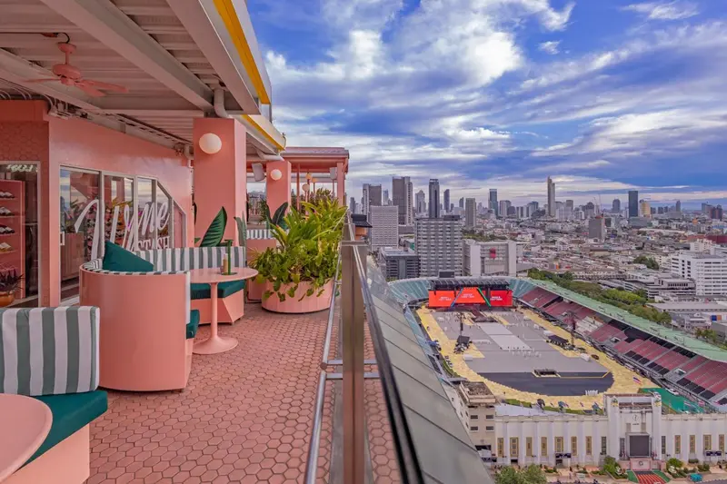 Terrasse aménagée avec mobilier coloré donnant sur une vue urbaine.