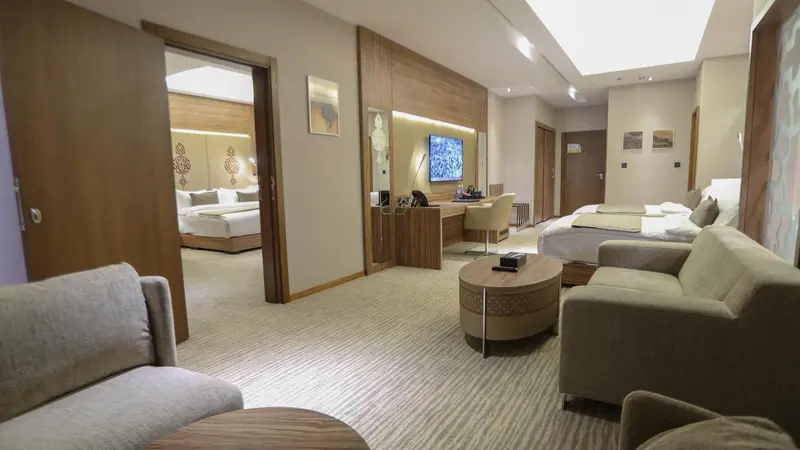 Espace de vie intérieur clair avec canapés, table basse et télévision.