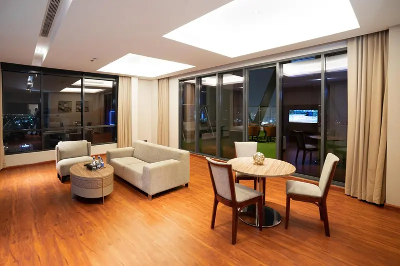 Un salon lumineux s'ouvre sur une terrasse avec vue nocturne.