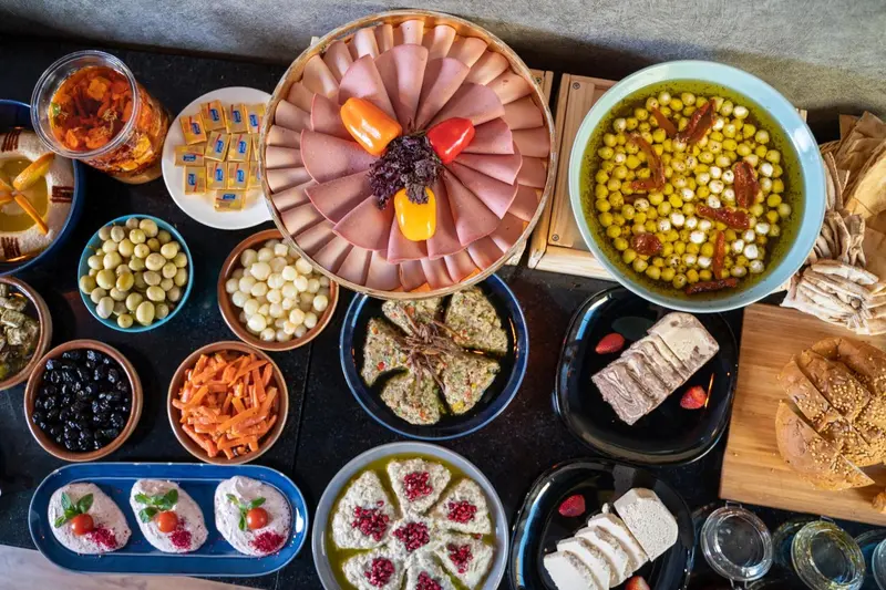 Assortiment de charcuteries, fromages, olives et crudités disposés sur un buffet.