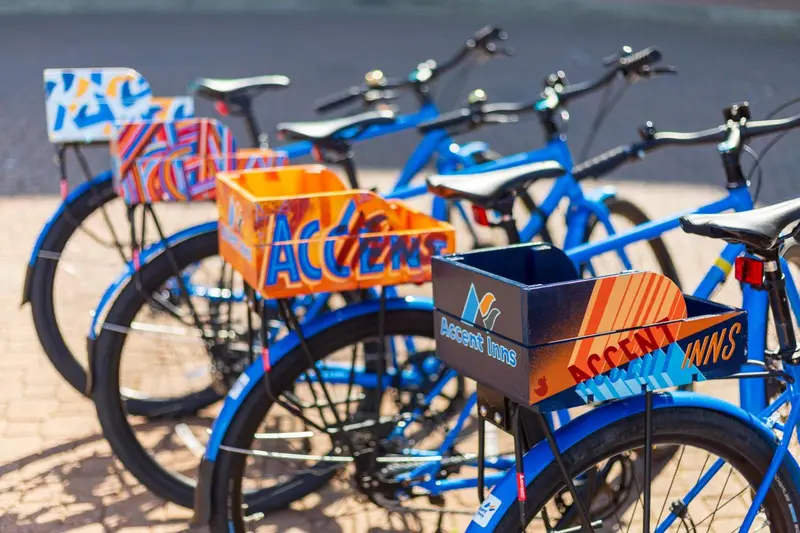 Vélos bleus alignés sur une plage de sable.