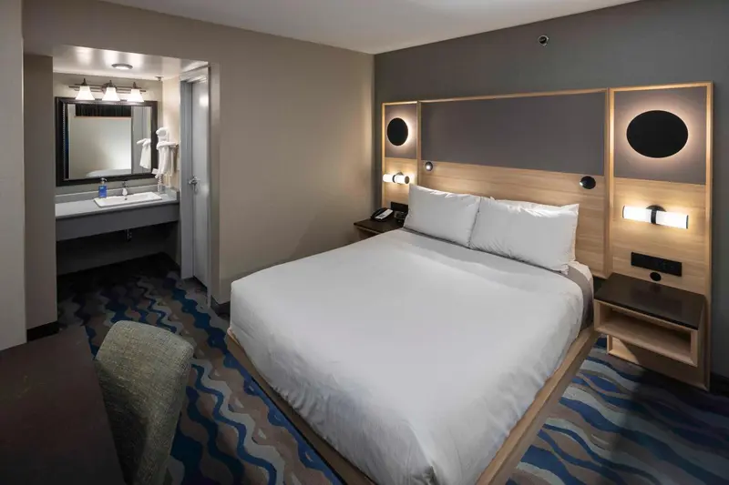 Une chambre d'hôtel moderne avec un grand lit et un espace lavabo.