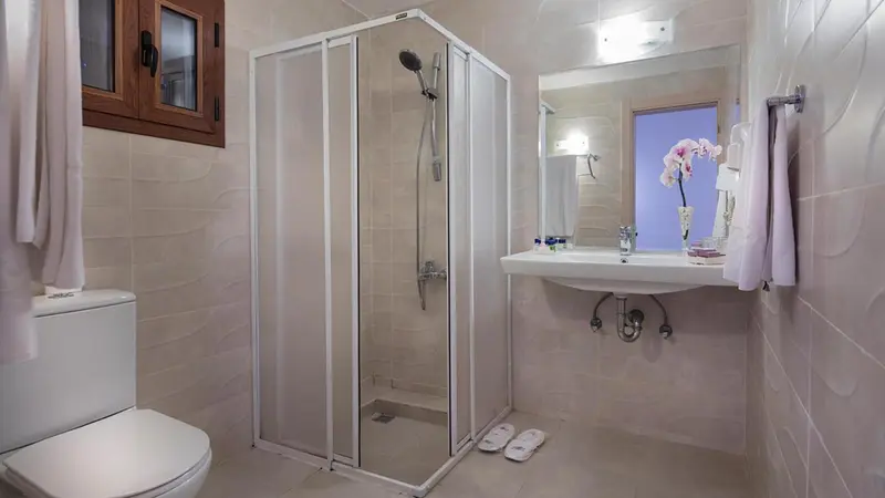Une salle de bain claire avec douche et lavabo.