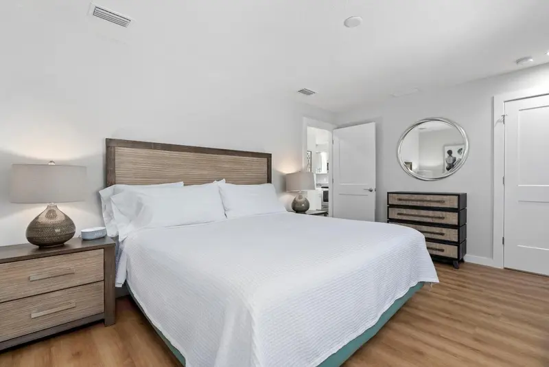 Une chambre lumineuse avec un grand lit et des meubles en bois.
