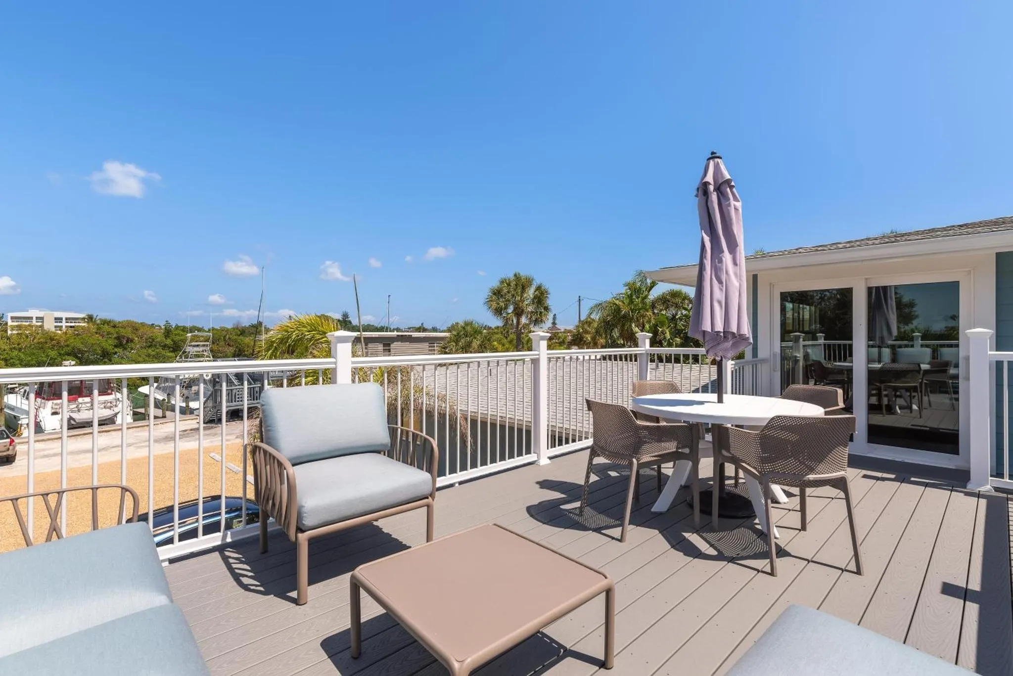 Terrasse aménagée avec salon de jardin et vue sur la mer.