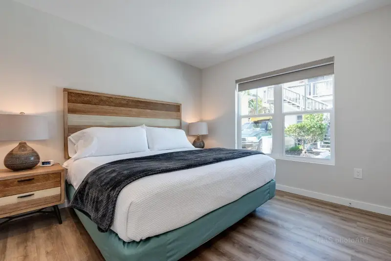 Une chambre lumineuse avec un grand lit et une fenêtre donnant sur l'extérieur.