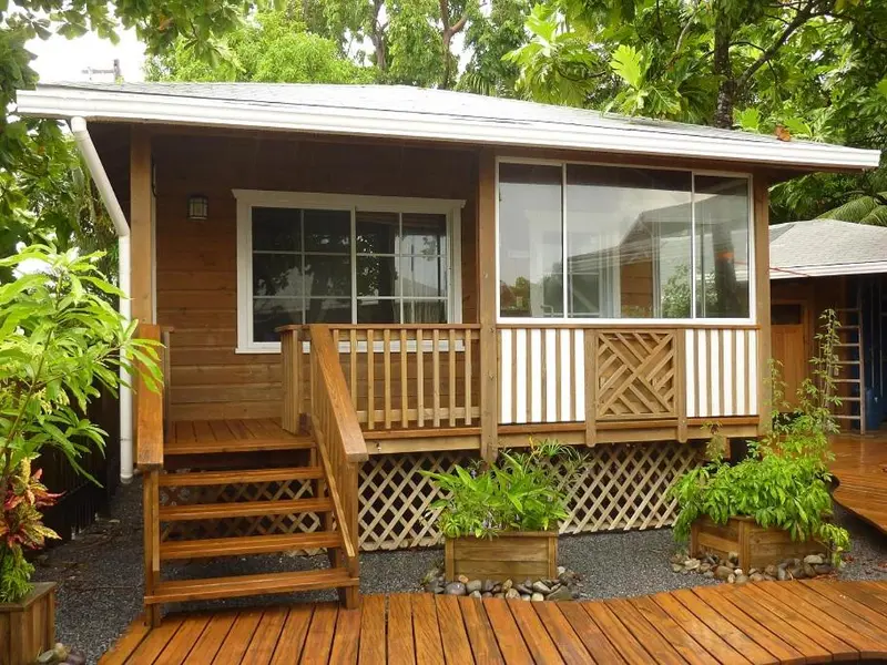 Une petite maison en bois avec une terrasse et des escaliers.