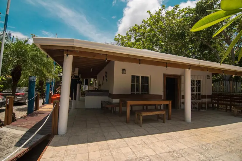 Terrasse ombragée avec tables et chaises en bois.