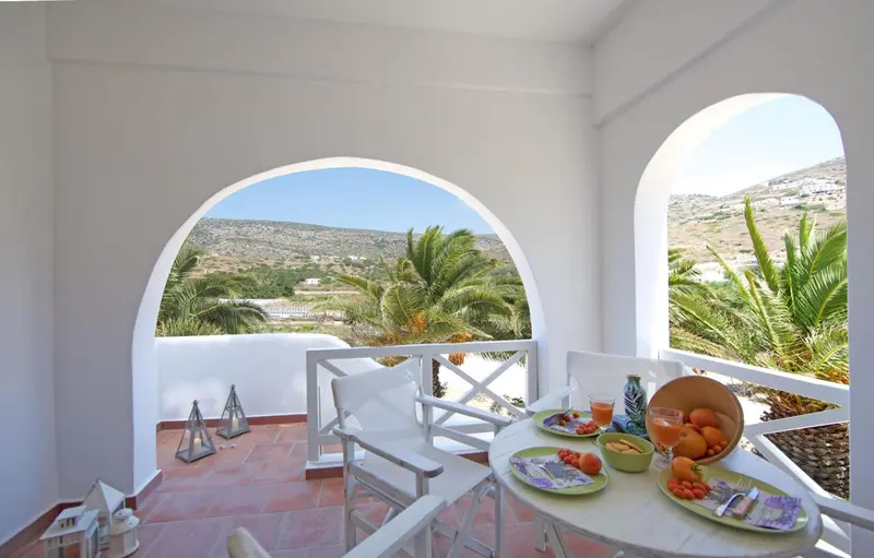 Une table est dressée sur une terrasse avec vue sur un paysage montagneux.