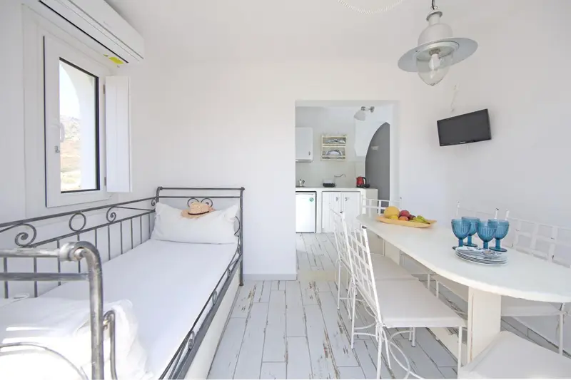 Une chambre lumineuse avec un coin repas et une kitchenette.
