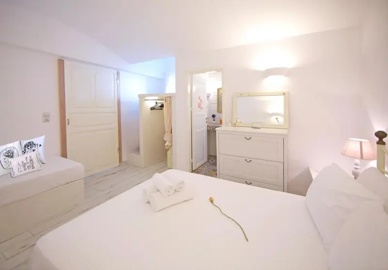 Une chambre lumineuse avec un lit et un coin salle de bain.